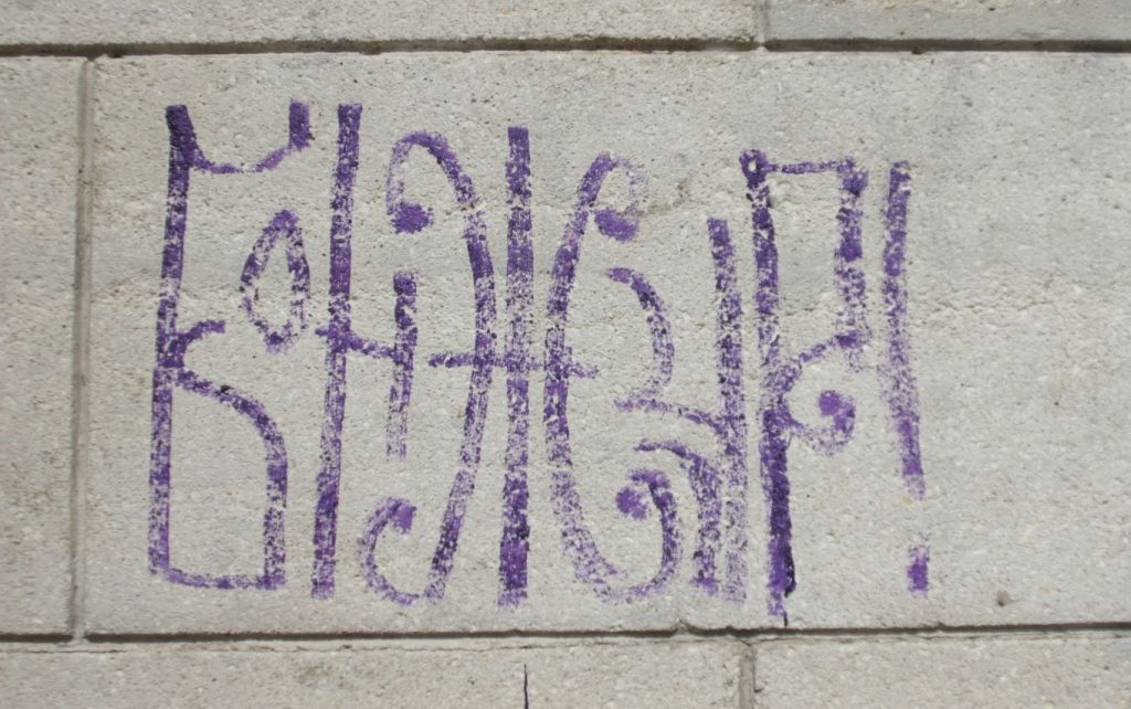 Graffiti auf einer Mauer, auf dem in kyrillischen Buchstaben "Bonjour" steht